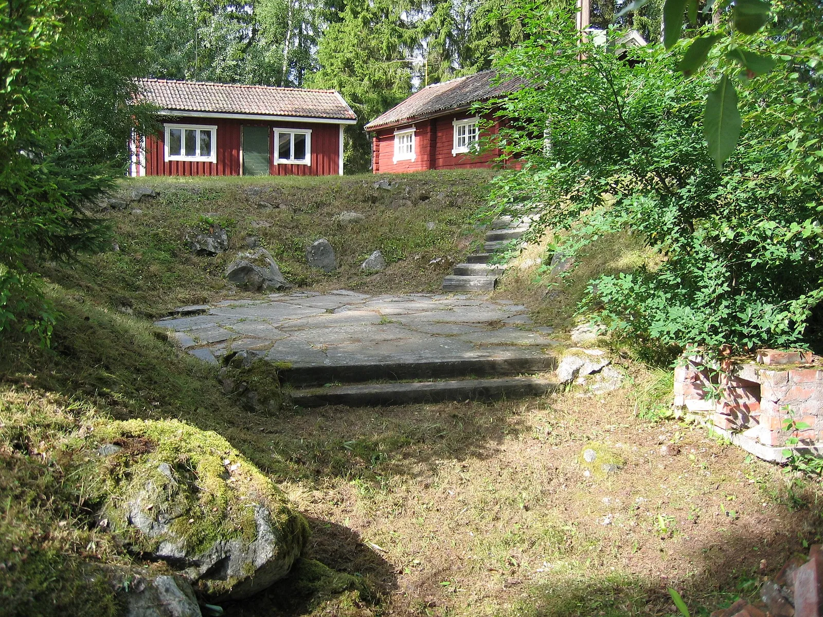 En stuga på en kulle i svensk sommar