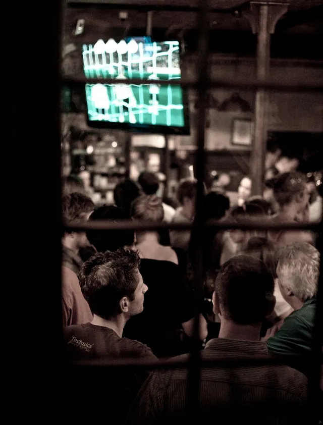 Människor tittar på fotboll på en bar