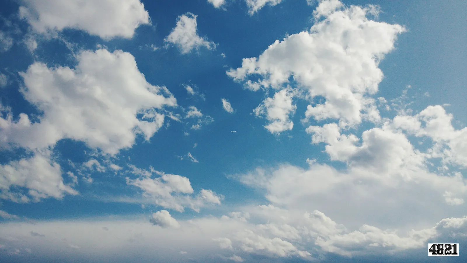 Vita stackmoln på en blå sommarhimmel