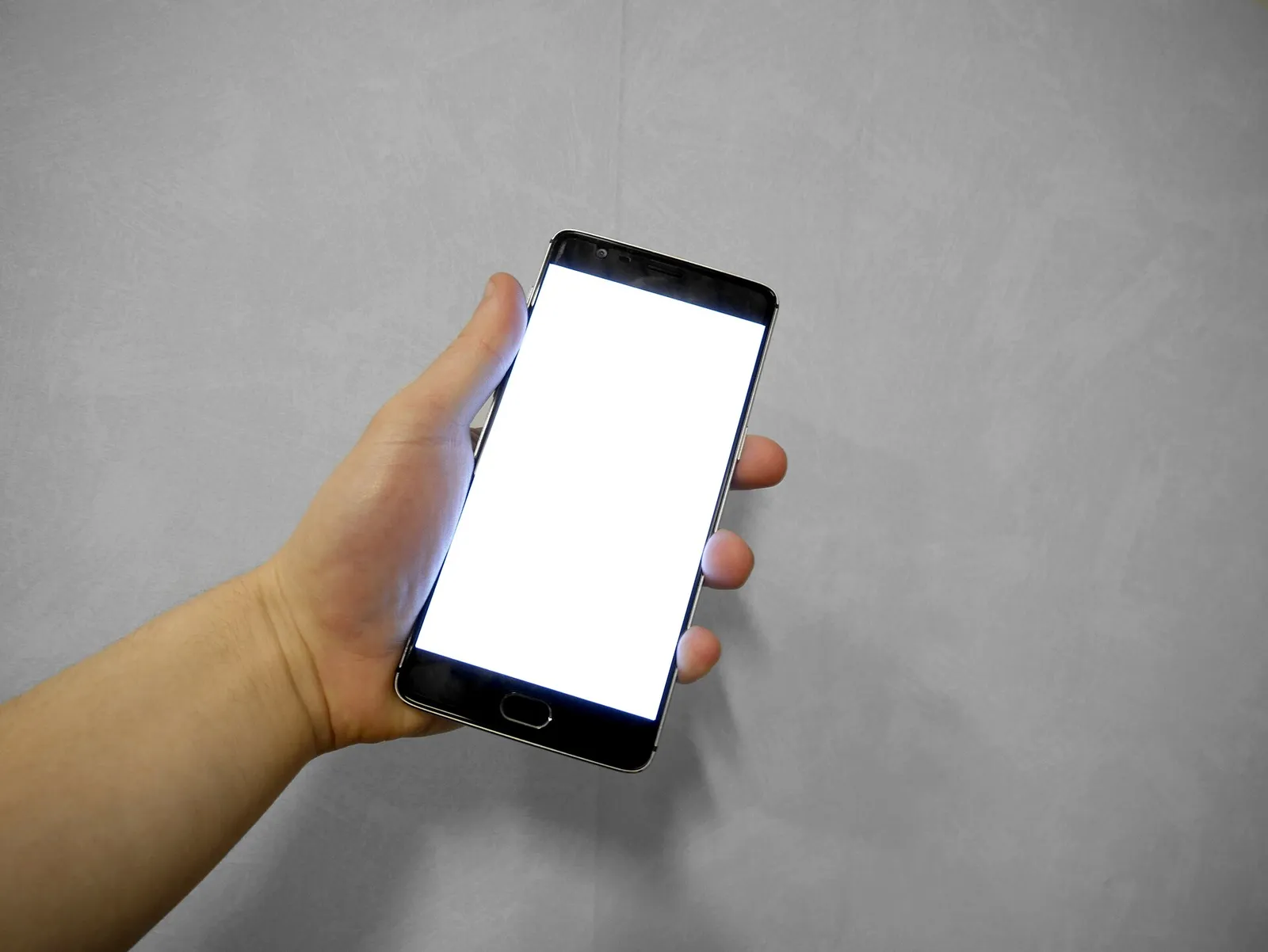 Arkivbild: en hand som håller en mobiltelefon.