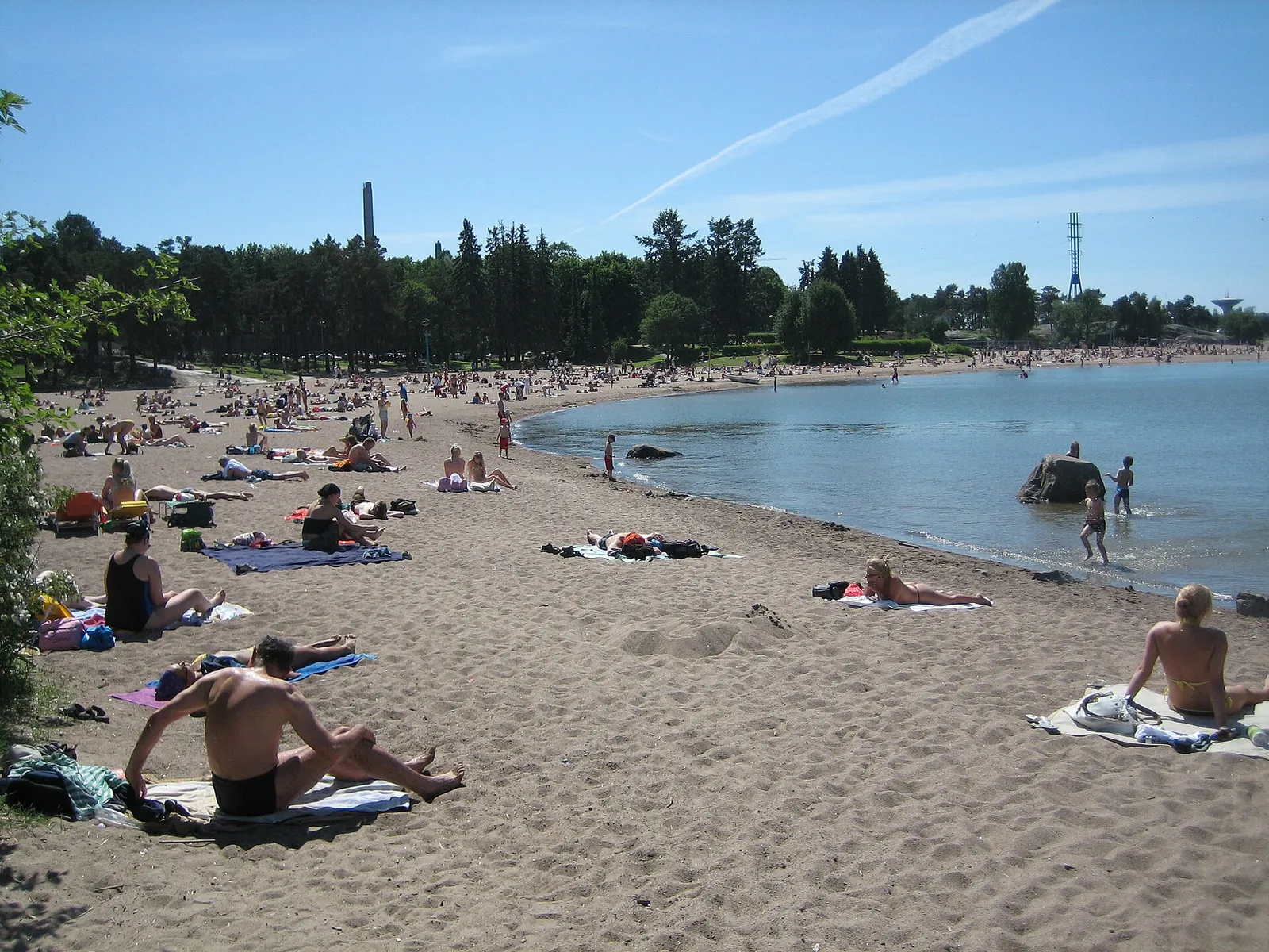 Solbadande på en nordisk stadsstrand en sommardag