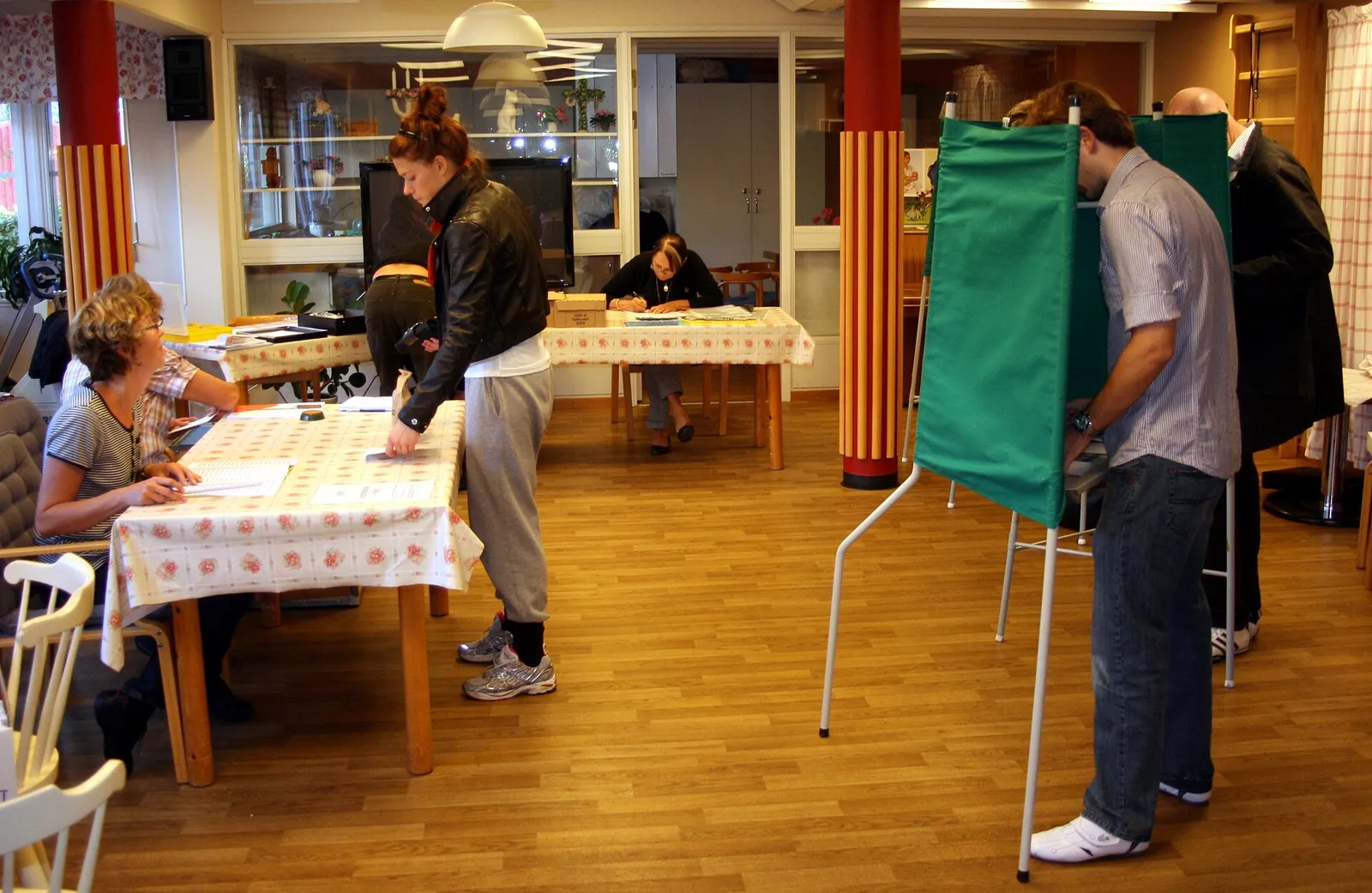 Väljare vid valskärmarna i en svensk vallokal