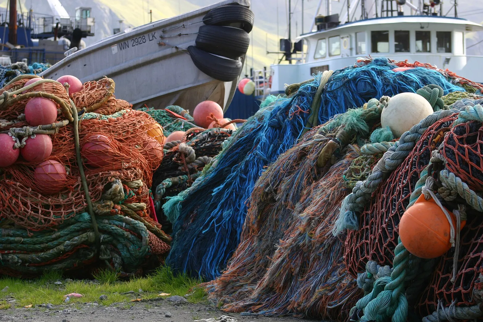 Hög med hopsamlade fiskenät i en hamn