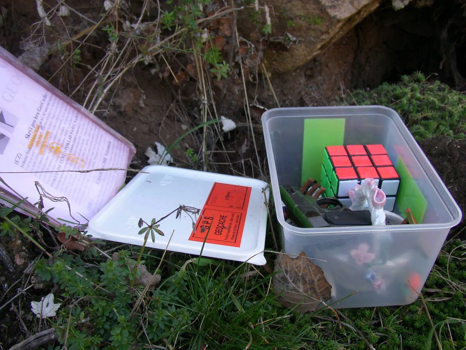 En geocache-behållare med loggbok och småsaker
