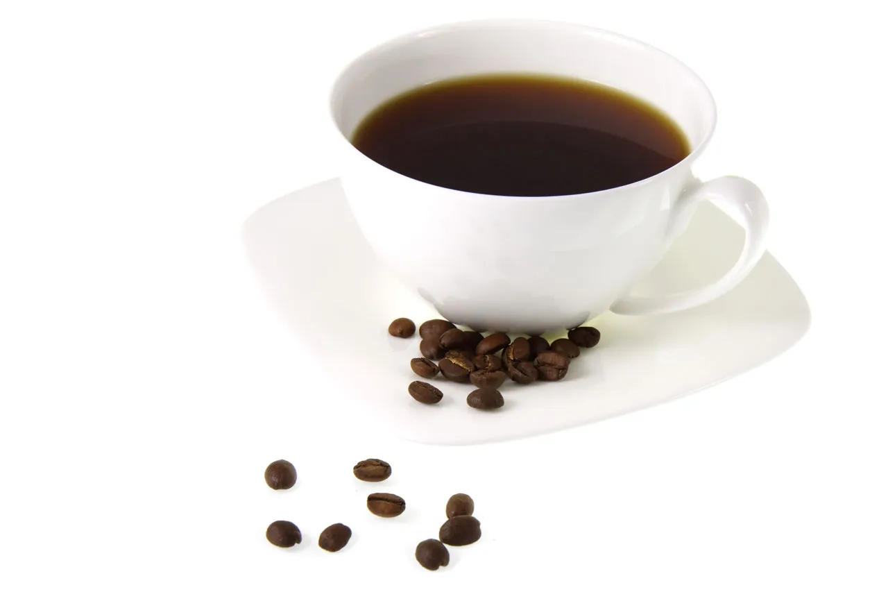 Arkivbild: en kopp kaffe och kaffebönor