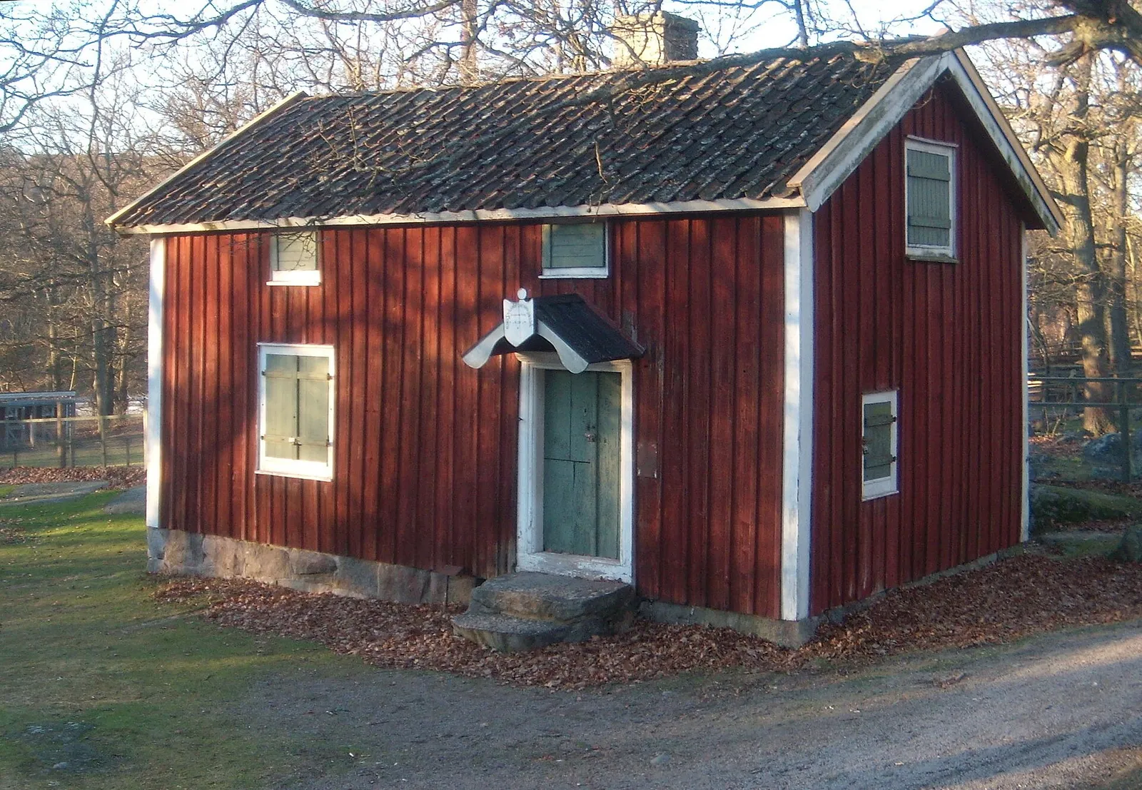 En röd stuga med vita knutar (genrebild)