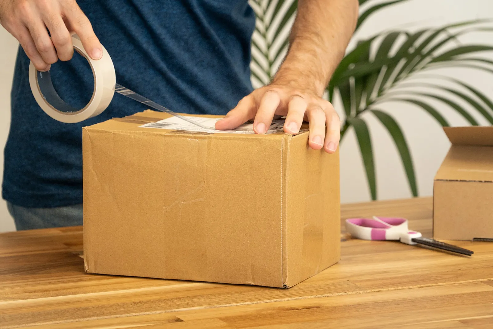 En etikett sätts på ett paket för frakt (genrebild)
